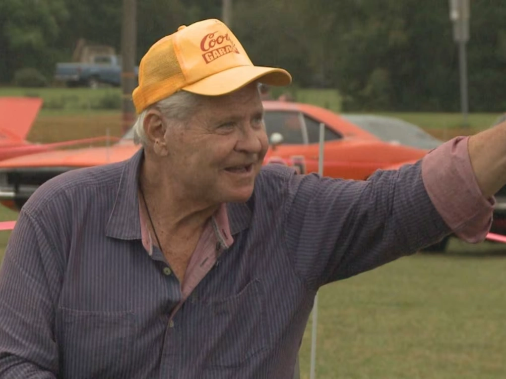 Ben Jones starring as Cooter Davenport beside the General Lee in The Dukes of Hazzard