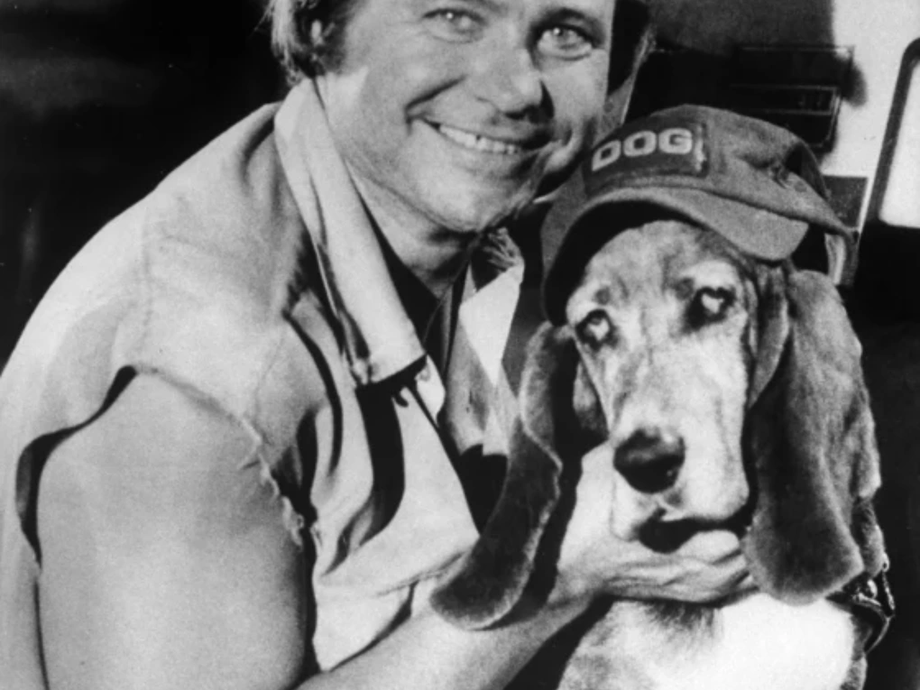 Ben Jones smiling as Cooter Davenport alongside iconic memorabilia from The Dukes of Hazzard
