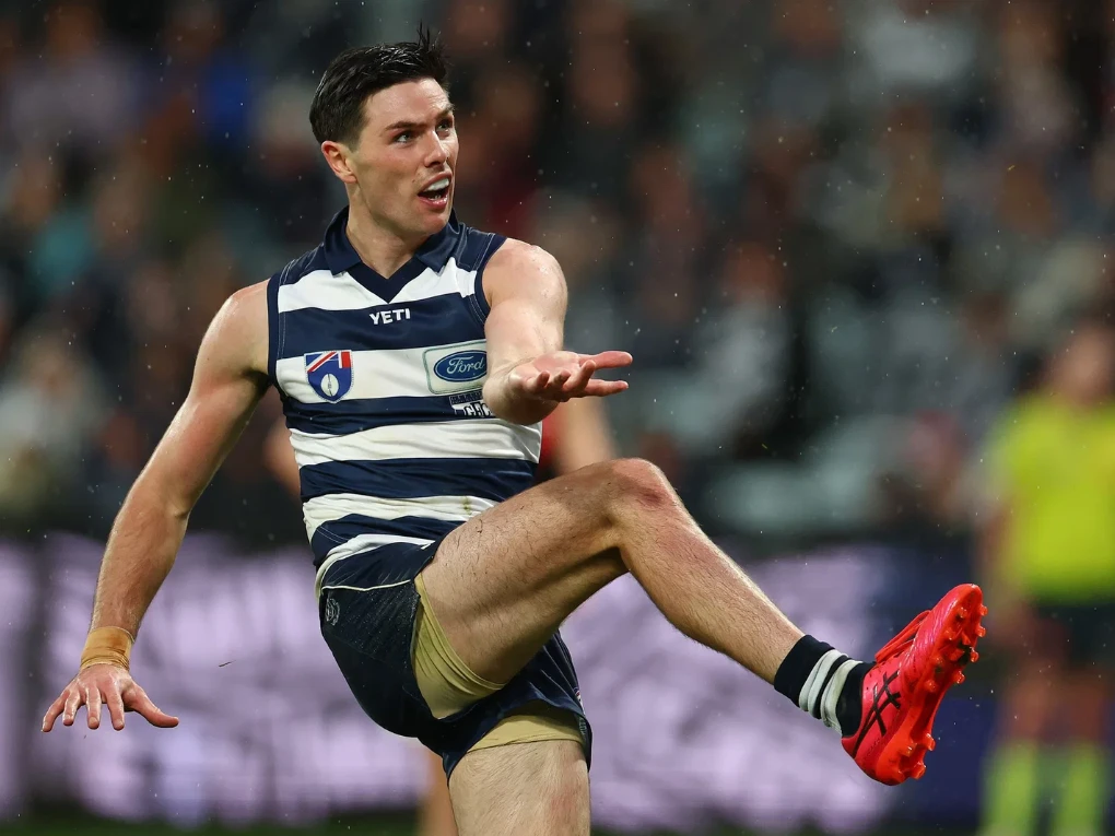 Geelong Cats and Essendon Bombers players competing in an AFL match at the MCG.