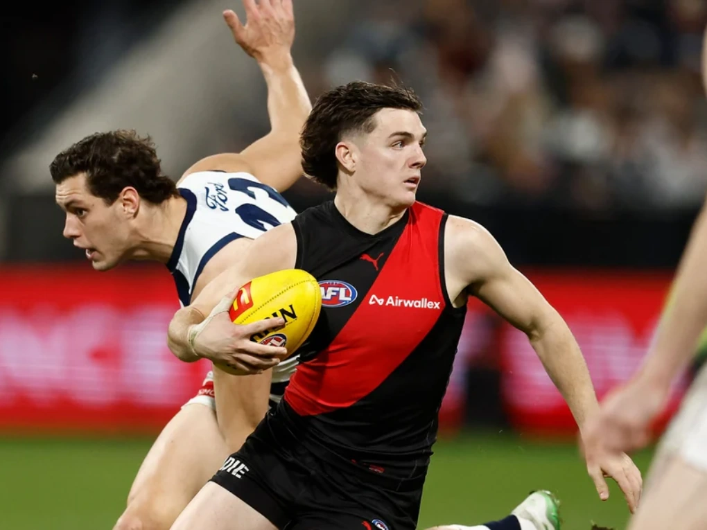 Geelong Cats and Essendon Bombers players competing in an AFL match at the MCG.